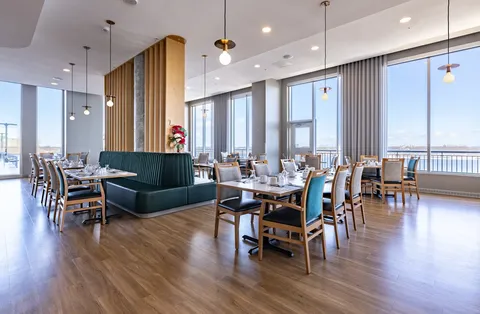 Dining room with set tables, upholstered chairs and large windows