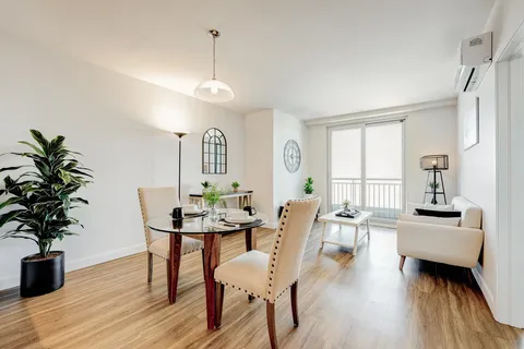 Room with a dining table, armchair and glass balcony door
