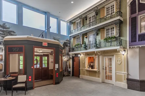 Lobby with decorative storefront facades and a tram-style doorway