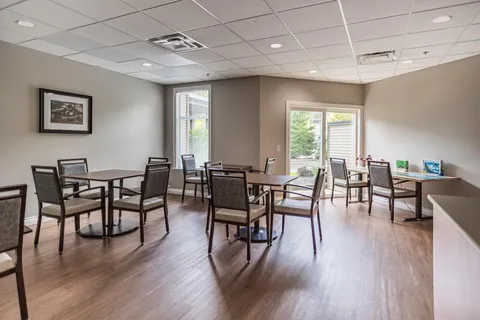 Room with square tables, chairs and a glass patio door