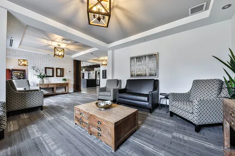 Seating area with a black sofa, patterned armchairs and a wooden table