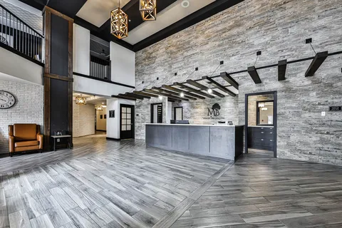 Lobby with a reception counter, stone wall and wood-patterned flooring