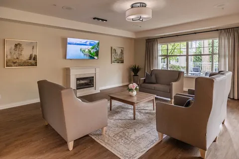 Lounge with armchairs, a sofa, a fireplace and large windows