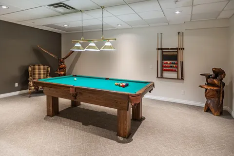 Billiards room with a green pool table and wooden animal sculptures