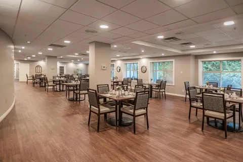 Dining room with square tables, upholstered chairs and windows