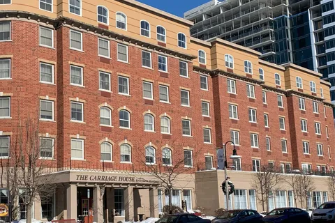 Brick residence building beside parked vehicles