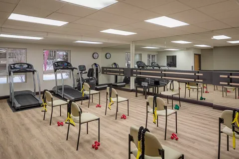 Fitness room with treadmills, exercise bikes, chairs and wall mirrors