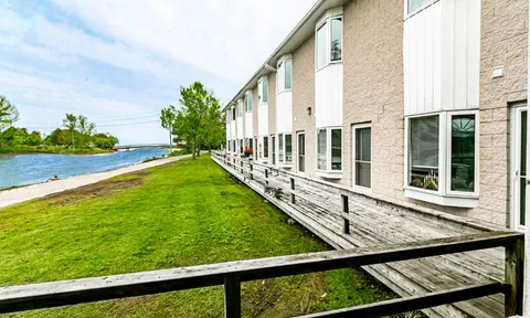 Residence beside the waterfront with lawn and a wooden walkway