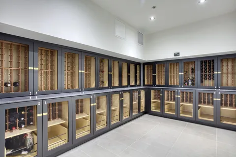 Glass-fronted storage cabinets for wine bottles.