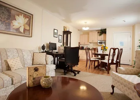 Suite sitting and dining area with a sofa, armchair and table.