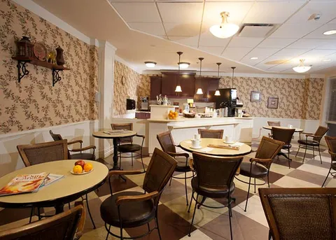 Café with round tables, chairs and a service counter.