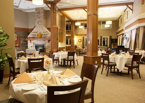 Dining room with set tables beneath a timber-framed ceiling.