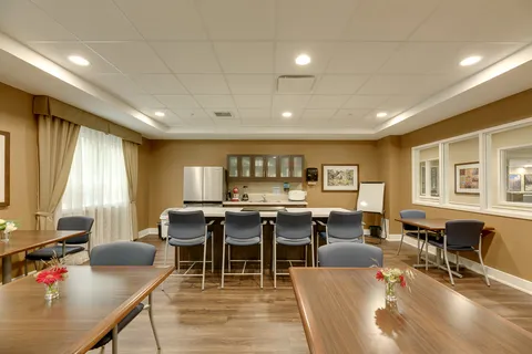 Room with a kitchen counter, blue chairs and tables