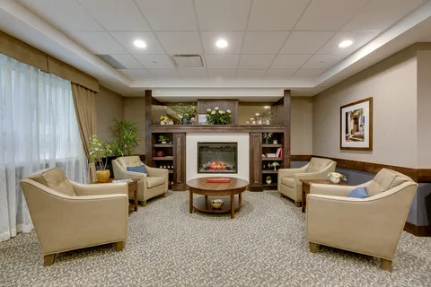 Sitting area with four armchairs around an electric fireplace