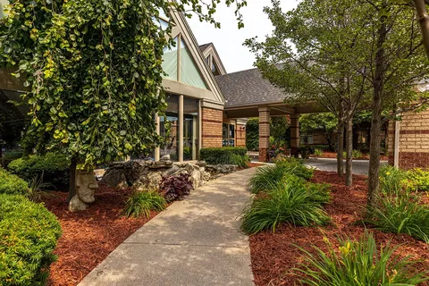 Landscaped path beside the residence entrance and garden beds.