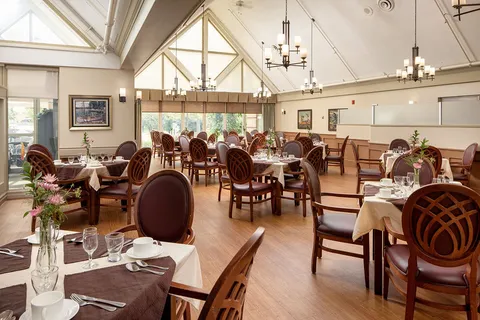 Dining room with set tables, chairs and a vaulted ceiling.