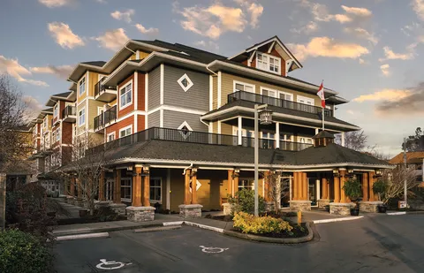 Multi-storey residence with balconies, covered entrance and driveway.