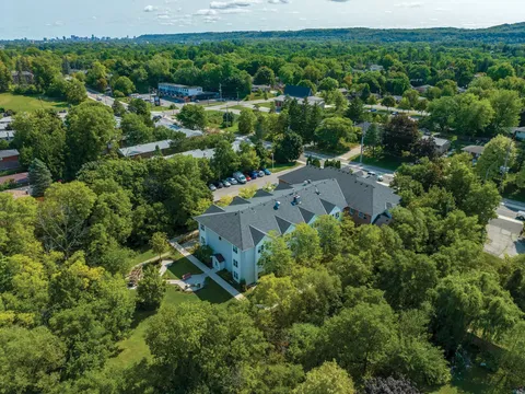 Aerial view of the residence building surrounded by lawns and trees