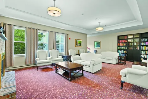 Lounge with white seating, windows and bookshelves