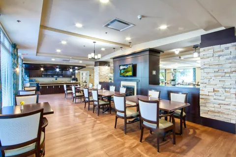 Bistro tables beside a service counter and stone fireplace.