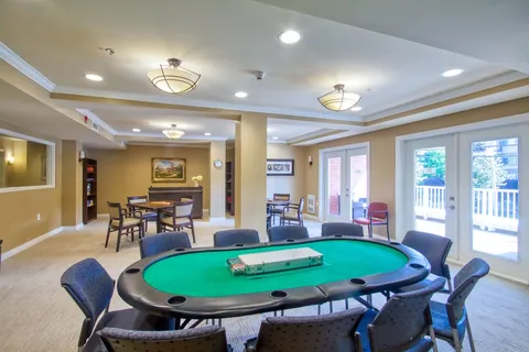 Games room with an oval card table and lounge seating.