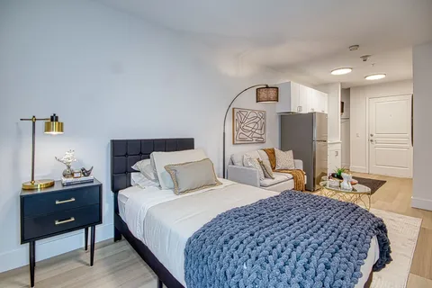 Bedroom with a bed, nightstand and doorway to a bathroom.