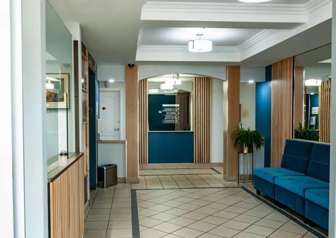 Lobby with blue seating, wood wall panels and tiled floor