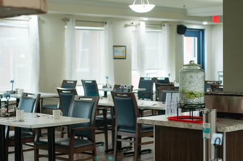 Dining tables and chairs beside a counter with a water dispenser
