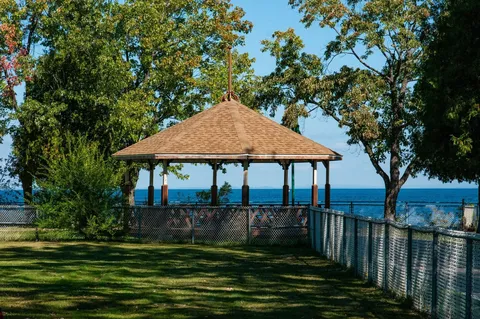 Gazebo and lawn beside trees overlooking the water