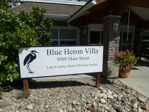 Residence sign and landscaped entrance beside the building.