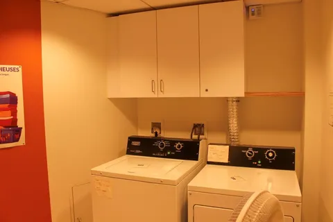 Laundry space with a washer and dryer beneath wall cabinets