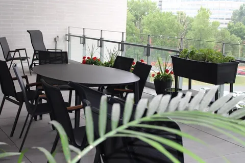 Covered balcony with a table, chairs and raised planters