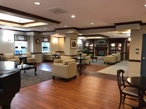 Room with armchairs, tables, a fireplace and display cabinets