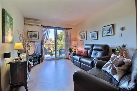 Suite living room with leather seating and a balcony door.