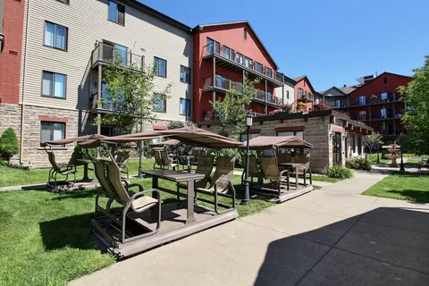 Residence courtyard facade with balconies, a paved path and outdoor seating.