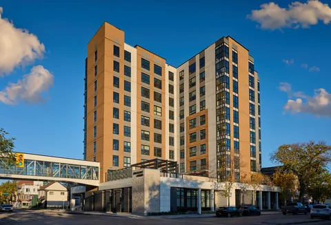 Multi-storey residence with an enclosed pedestrian bridge and street frontage.