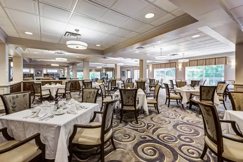 Dining room with set tables, patterned chairs and large windows
