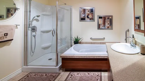 Bathroom with a bathtub, separate shower, vanity and mirror