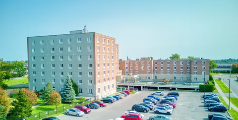 Aerial view of a multi-storey residence and its parking area