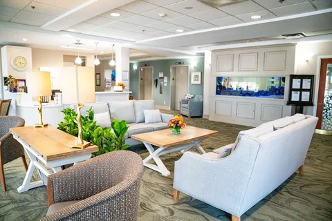 Sitting area with grey sofas, armchairs, coffee tables and an aquarium