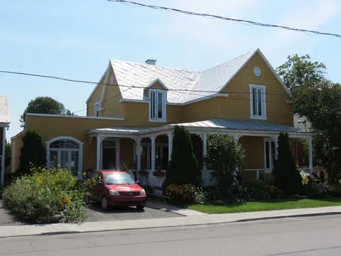 Residence facade with a covered veranda and driveway.
