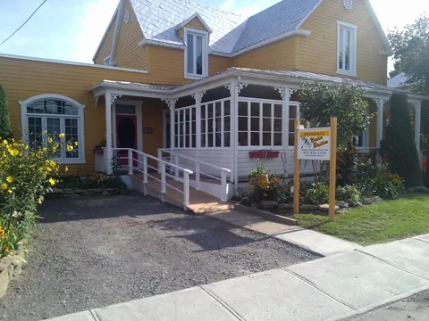 Yellow residence with covered front porch and accessibility ramp.