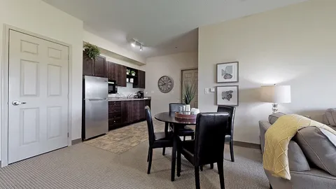 Kitchen and dining area beside a sofa and framed artwork