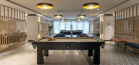 Billiards table in a room with seating and wood partitions