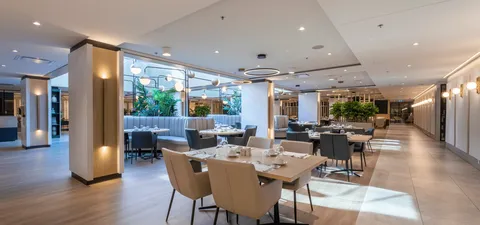 Dining room with set tables, chairs and padded booth seating