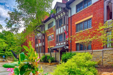 Rear facade of the residence beside garden beds and trees.