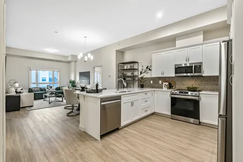 White kitchen with an island opening onto a sitting area
