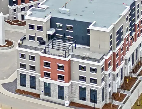 Aerial view of the building with a rooftop patio and pergola