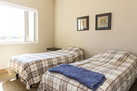 Suite bedroom with two single beds beneath a window.
