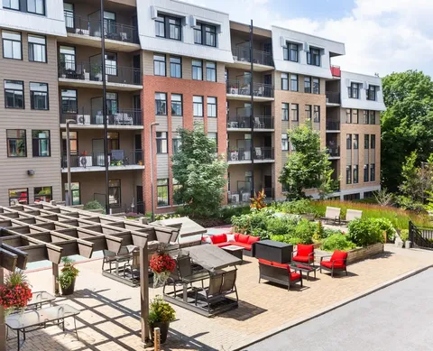 Residential building with balconies beside a furnished courtyard